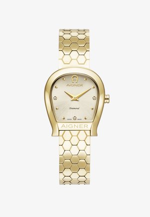 Guldtonet ur med sekskantet ledrem, oval urskive og diamantdetaljer. Har en lysefarvet urskive og AIGNER-logo. Fremstillet i Schweiz.