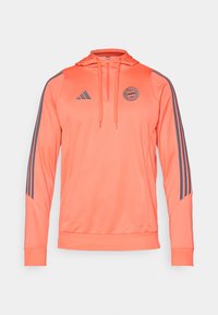 Oransje hettegenser med grå Adidas-striper og logo. Laget av glatt stoff, har glidelås og ribbestrikkede mansjetter og nederkant.
