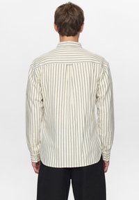 Gestreept shirt met lange mouwen in crème en marineblauw, met een plooitje aan de achterkant en met knopen verstelbare manchetten, gemaakt van gestructureerde katoenen stof.