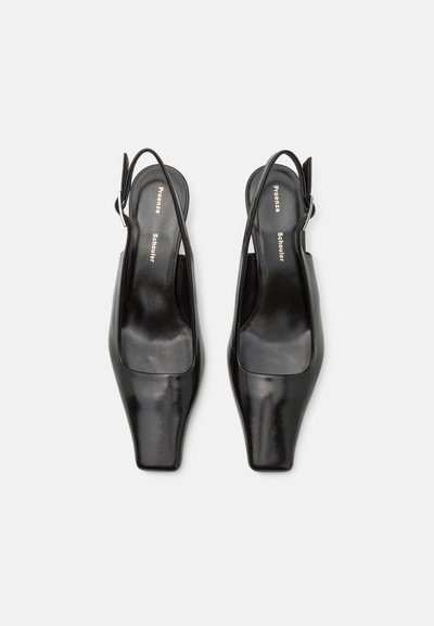 Sorte læder slingback sko med firkantet tå, glat tekstur og en sølv spænde accent, præsenteret på en neutral baggrund.