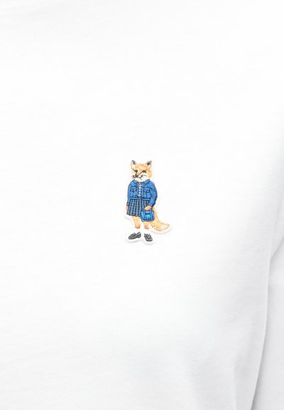 Λευκή φούτερ μπλούζα με κεντημένο αλεπού που φοράει μπλε ζακέτα, γκρι πλισέ φούστα και μαύρα παπούτσια, με ουρίτσα και μουστάκια σε κρεμ απόχρωση.