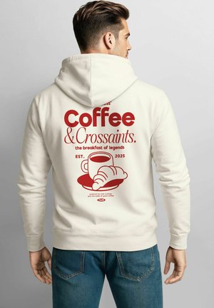 Helle Hoodie in Creme mit rotem Text: "Kaffee & Croissants," Grafik einer Kaffeetasse und einem Croissant, darunter "EST. 2025."