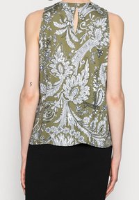 Top senza maniche verde oliva con stampa floreale paisley bianca, dettaglio apertura a chiave sul retro e tessuto leggero e morbido.