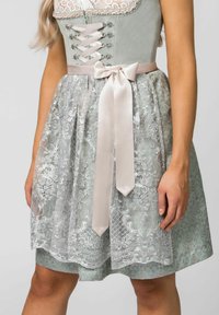 Traditional dress with a light green bodice and a lace overlay skirt. Features a satin ribbon tied at the waist and silver floral patterns.