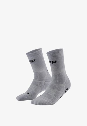 Paar hellgraue Sportsocken mit schwarzer Beschriftung, gerippten Bündchen und gepolsterten Bereichen für Unterstützung und Komfort.