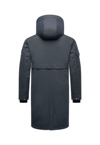 Tamsiai mėlyna parka su kapišonu, ilgomis rankovėmis, reguliuojamais rankogaliais, priekinėmis kišenėmis su atvartais ir raišteliu juosmeniui, kad būtų pritaikytas fitas.