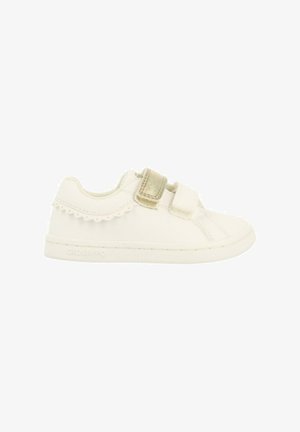 Zapatilla blanca hecha de cuero sintético, con dos correas de Velcro, acentos con bordes ondulados y una suela texturizada. Detalles de diseño sutiles mejoran la estética.