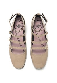 Bailarinas de charol en color beige con tres correas ajustables y una punta redondeada. El interior cuenta con una plantilla acolchada con un diseño de corazón.