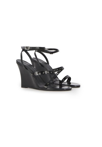 Black wedge sandals with thin ankle and toe straps, featuring small metal eyelet details along the straps.