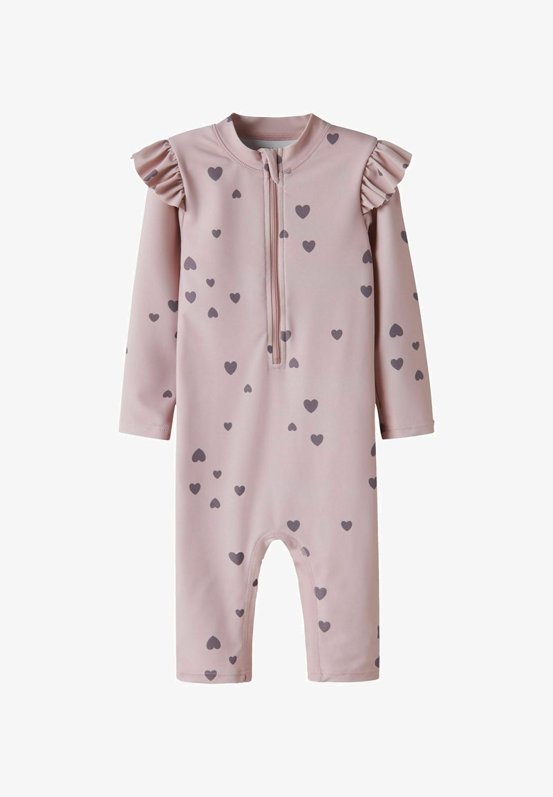 Grenouillère bébé rose à manches longues avec motifs de cœurs gris, fermeture éclair à l'avant et détails à volants sur les épaules.