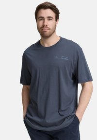 Marineblauwe katoen t-shirt met korte mouwen en een ronde hals. Heeft een subtiele "Tom Tailor" logo in lichtblauw op de borst.