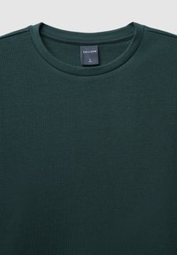 Felpa in cotone verde scuro con texture, colletto rotondo, caratterizzata da un motivo intrecciato e un'etichetta interna che indica la taglia L.