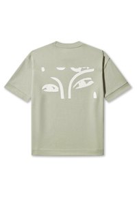 Lys grøn t-shirt i bomuld med rund hals og korte ærmer. Har et stort hvidt grafisk motiv af abstrakte øjne på ryggen.