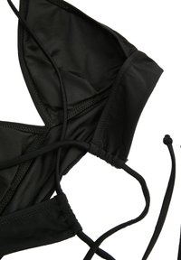 Zwarte bikini-top gemaakt van een gladde stof. Bevat driehoekige cups met geplooide naden en verstelbare strikken. Geen aanvullende patronen of hardware.