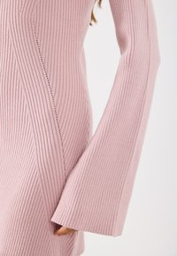 Ροζ ριγωτό πλεκτό φόρεμα με μακριά φαρδιά μανίκια, διαθέτει κάθετη ρίγα και λεπτές ραφές κατά μήκος των ραφών. Λείος υφασμα.