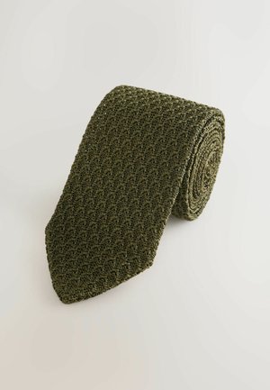 Grüne, gerollte Strickkrawatte mit texturiertem Muster und spitzem Ende. Hergestellt aus einem flexiblen Material mit matter Oberfläche.