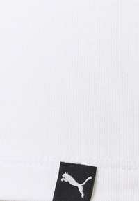 White ribbed fabric tank top with a black Puma logo tag at the hem. Soft texture and fitted design.