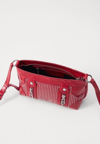 Sac à main en cuir rouge avec des clous argentés, fermetures à glissière doubles et une bandoulière ajustable. Intérieur doublé en tissu noir. Design compact et structuré.