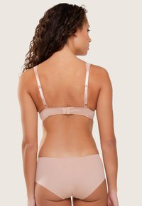 Sujetador nude con espalda de encaje, tirantes ajustables y cierre de gancho y ojo. Tejido suave con textura lisa y acabado sin costuras.