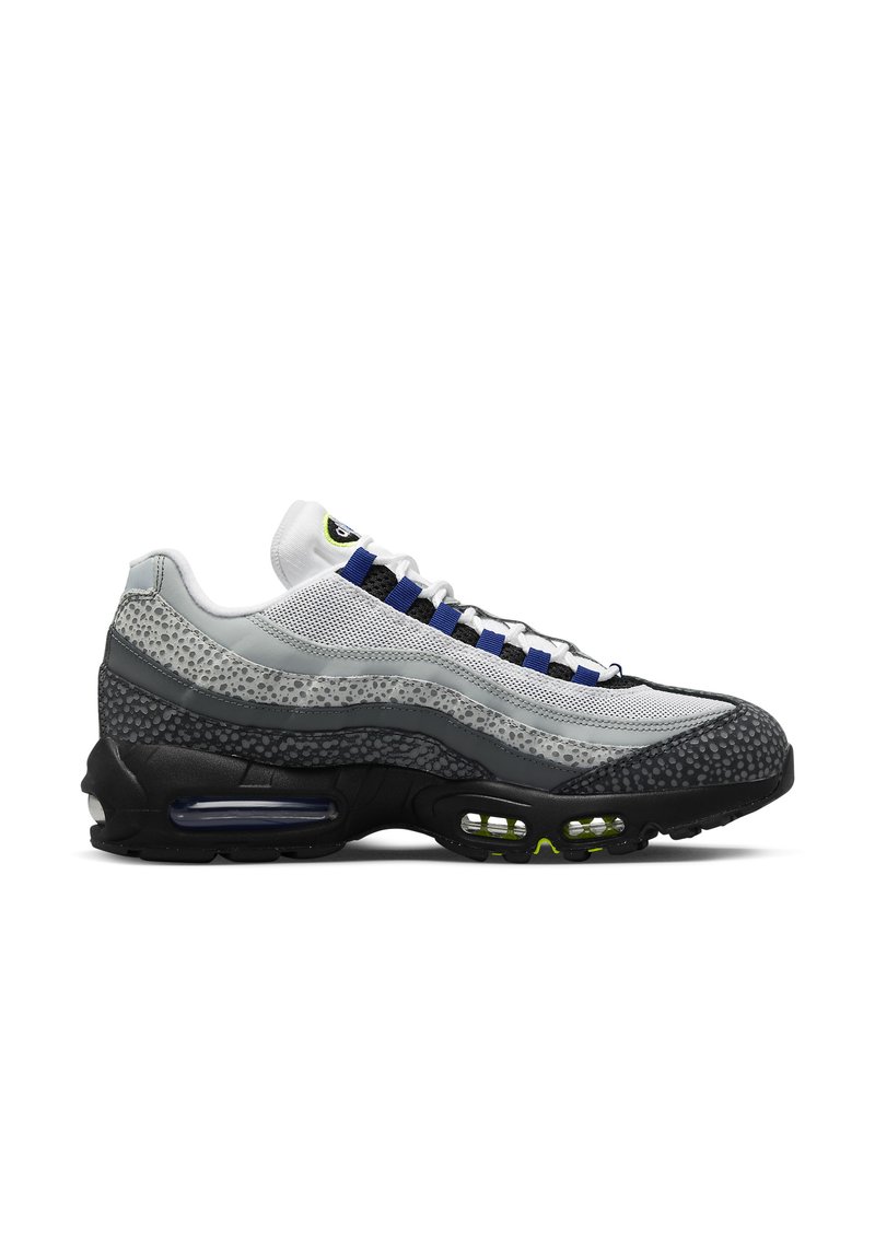 Zapatilla gris y negra con malla y acentos texturizados, que presenta un diseño curvado, amortiguación de aire visible y cordones azules.