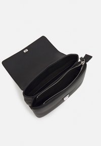 Black leather bag with a zip closure, featuring a spacious interior divided by a zipper pocket, smooth texture, and metal accents.
