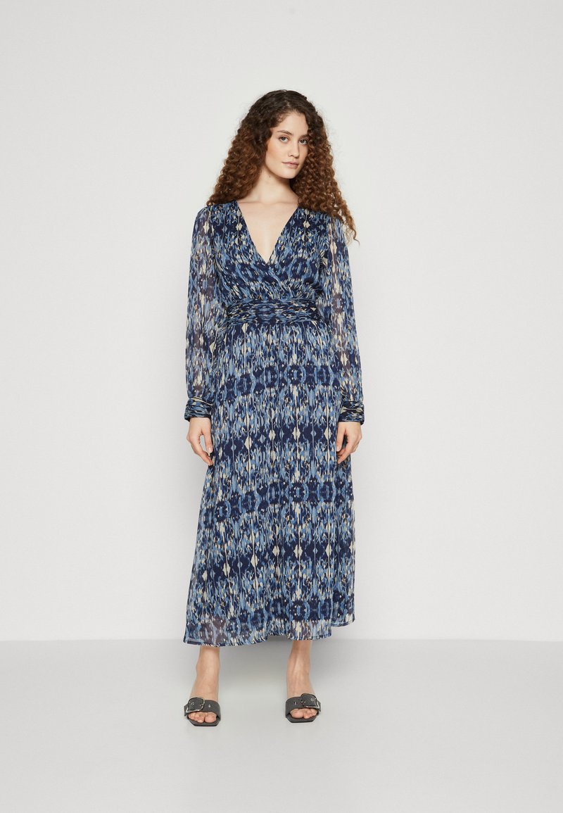 Rochie lungă, fluidă, cu un model albastru și crem, având un decolteu adânc în V, mâneci lungi din material transparent și o talie strânsă.