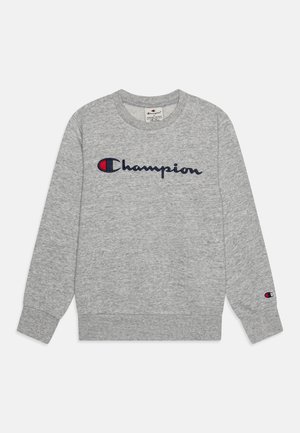 Lysegrå crewneck-sweatshirt med lange ærmer, med "Champion" logo i marineblå og rød på tværs af brystet og et lille logo på venstre ærmekant.