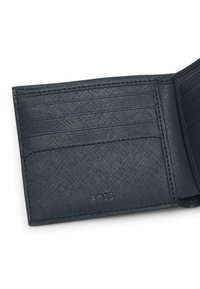 Portacarte in pelle nera con texture a rilievo, molteplici scomparti per carte e bordi cuciti. Presenta il logo del marchio nella parte inferiore anteriore.