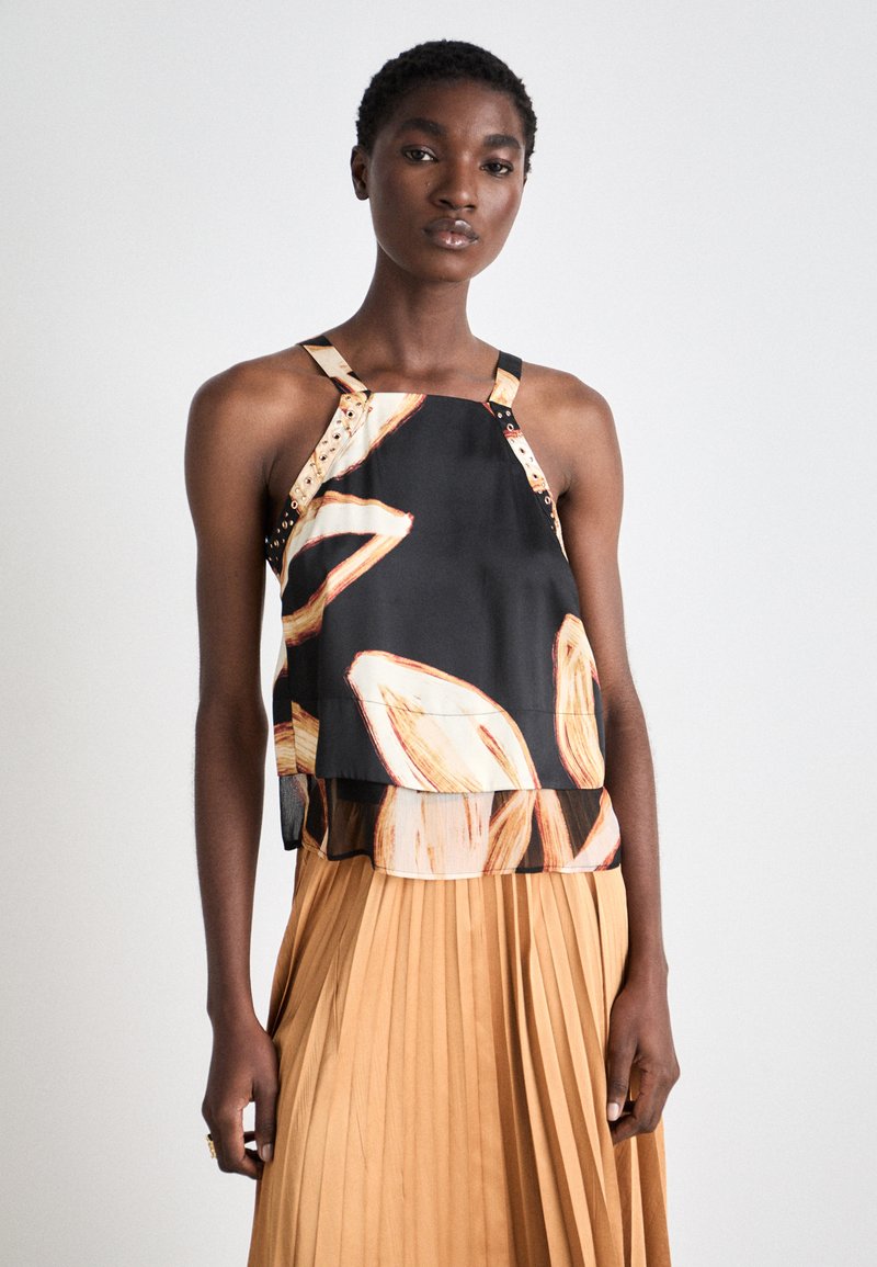 Top en soie noire avec de grands motifs floraux en crème et orange, doté de larges bretelles et d'un ourlet en couches.