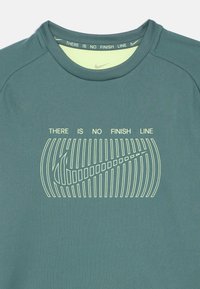 Ciemnoniebieska koszulka sportowa z okrągłym dekoltem, krótkimi rękawami i białym nadrukiem z tekstem „NIE MA LINII METY” oraz logo Nike.