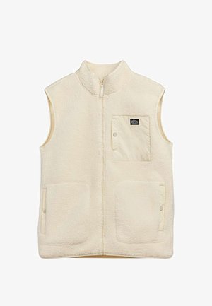 Veste sans manches en polaire crème avec fermeture éclair à l'avant, deux poches plaquées basses avec boutons-pression, et une poche poitrine avec bouton-pression et patch logo noir.