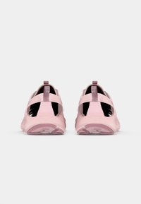 Różowe buty sportowe z oddychającym designem, charakteryzujące się teksturowaną powierzchnią i amortyzowaną podeszwą. Widok z tyłu z pętelkami ułatwiającymi zakładanie.