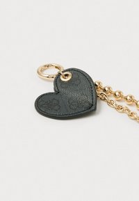 Portachiavi a forma di cuore nero realizzato in pelle testurizzata, dotato di un anello dorato e di una catena con perline tonde per il fissaggio.