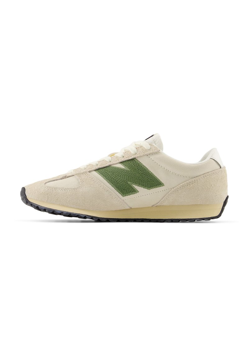 Αθλητικό παπούτσι με επάνω μέρος από μπεζ δέρμα και πράσινο σουέντ, με υφή, στρογγυλή μύτη, λευκά κορδόνια και μαύρη ελαστική σόλα.