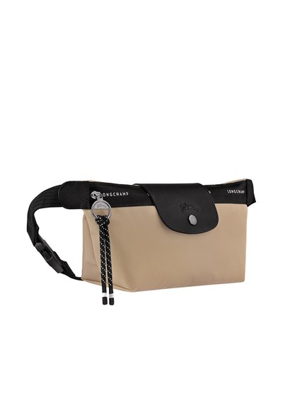 Beige nylon bag with a black leather flap, featuring a snap closure and contrasting strap with polka dots. Logo embossed on the flap.