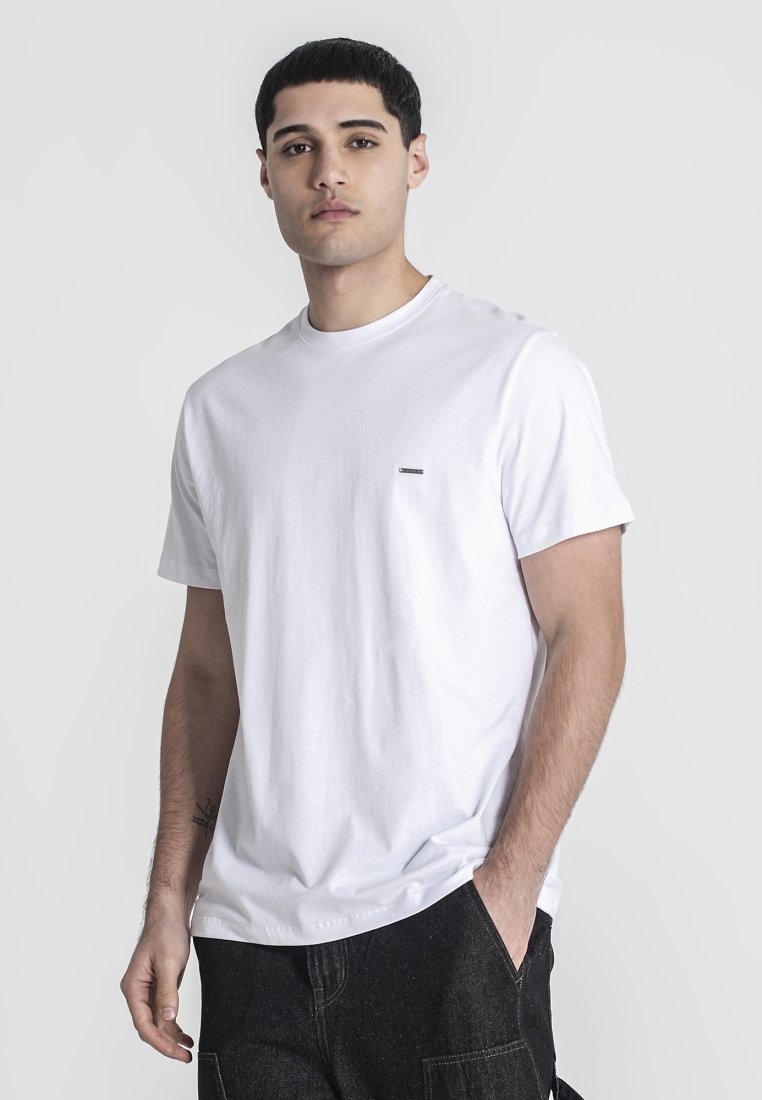 Weißes Baumwoll-T-Shirt mit Rundhalsausschnitt und kurzen Ärmeln, mit einem kleinen schwarzen Logo auf der linken Brust und einem lockeren Schnitt.