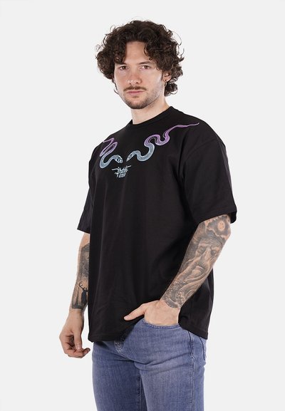 T-shirt nera in cotone con motivi ondulati colorati in viola e blu sul colletto. Vestibilità comoda con maniche corte e scollo rotondo.