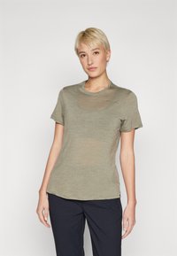 Alyvuogių žalios spalvos, trumpomis rankovėmis marškinėliai pagaminti iš minkštos, lengvos medžiagos, su apvaliu iškirpimu ir subtiliu logotipo akcentu ant krūtinės.