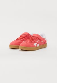 Koralni antilop patike s bijelim detaljima i vezicama, s trakama, gumeni potplat, i Reebok oznaka sa strane.