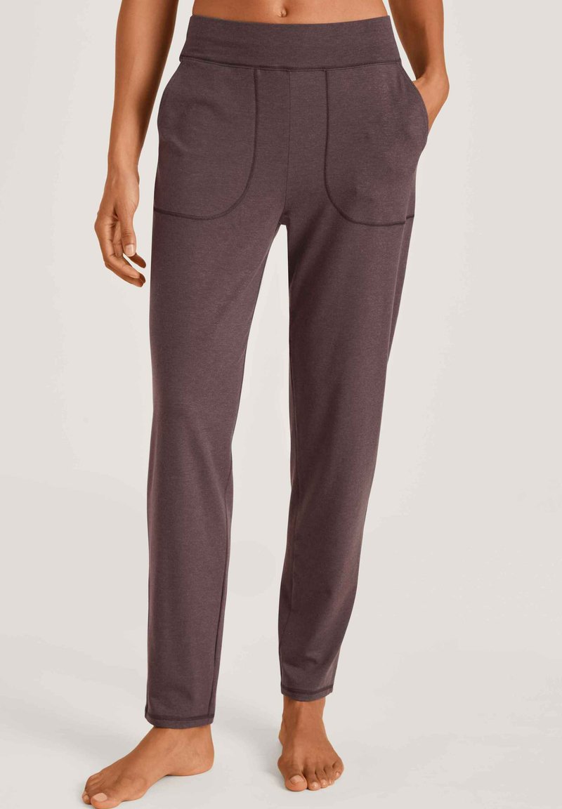 Donkerpaarse joggingbroek van zacht materiaal. Beschikt over een brede elastische tailleband, twee frontzakken en zichtbare stiksels.