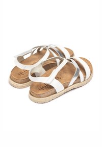 White and silver strappy sandals with a cork footbed, textured finish, and jute-wrapped sole. Soft interior and adjustable straps.