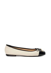 Ballerines en cuir crème et noir. Dotées d'un bout arrondi avec une coque laquée, d'un accent noeud et d'un talon plat. Texture lisse sur l'ensemble.