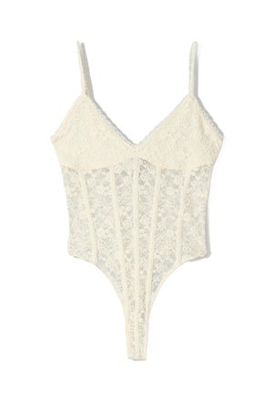 Body en dentelle blanche avec fines bretelles réglables, motif floral, encolure en V et détails en mesh transparent le long du torse.