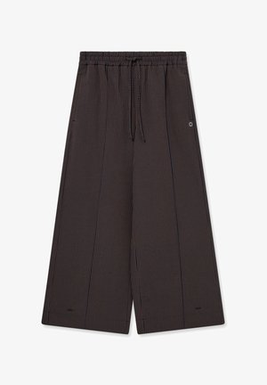 Hose mit weitem Bein, dünnen vertikalen braunen und schwarzen Streifen, elastischem Bund und Kordelzugverschluss.