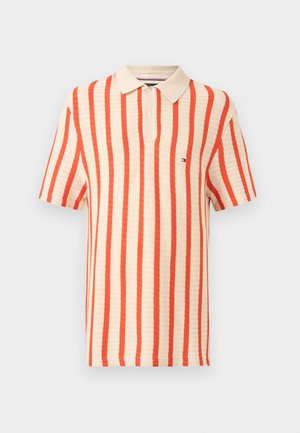 Beige polo met korte mouwen met verticale oranje strepen en een knoopsluiting met twee knopen, met een klein logo op de borst.