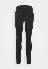 Jeans skinny de denim negro, con un acabado liso, ajuste ceñido y dos bolsillos traseros con un diseño de costura sutil.