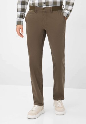 Braune Baumwollhose mit schmaler Passform, seitlichen Taschen, Knopfverschluss und glatter Textur, kombiniert mit hellen Sneakern.