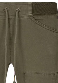 Jogging en vert olive avec une taille côtelée, des cordons de serrage et une poche latérale. Fabriqué en tissu lisse et avec des coutures plates pour une apparence épurée.