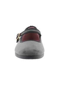 Zapato plano gris con una textura suave y lisa, una sola correa negra y punta redonda. El interior presenta un forro burdeos. Suela plana.