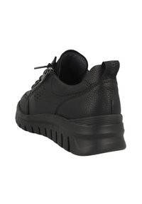 Zapatilla de cuero negra con un acabado texturizado, que presenta un perfil bajo, punta redondeada y suela de goma con patrones de relieve visibles.